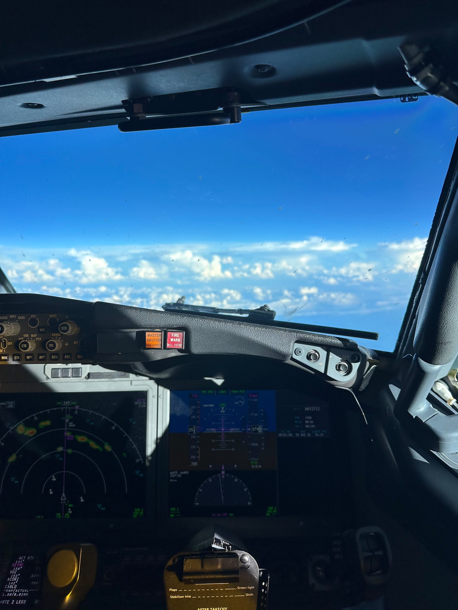 Cabina de una aeronave sobre un manto de nubes