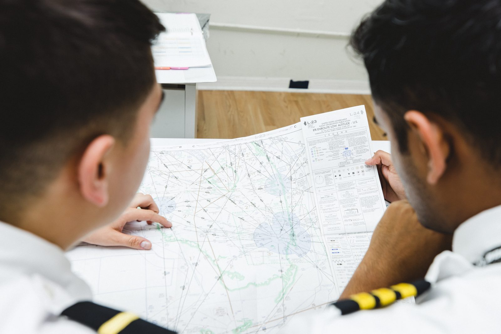 Pilotos revisando una carta de navegación durante una sesión de preparación
